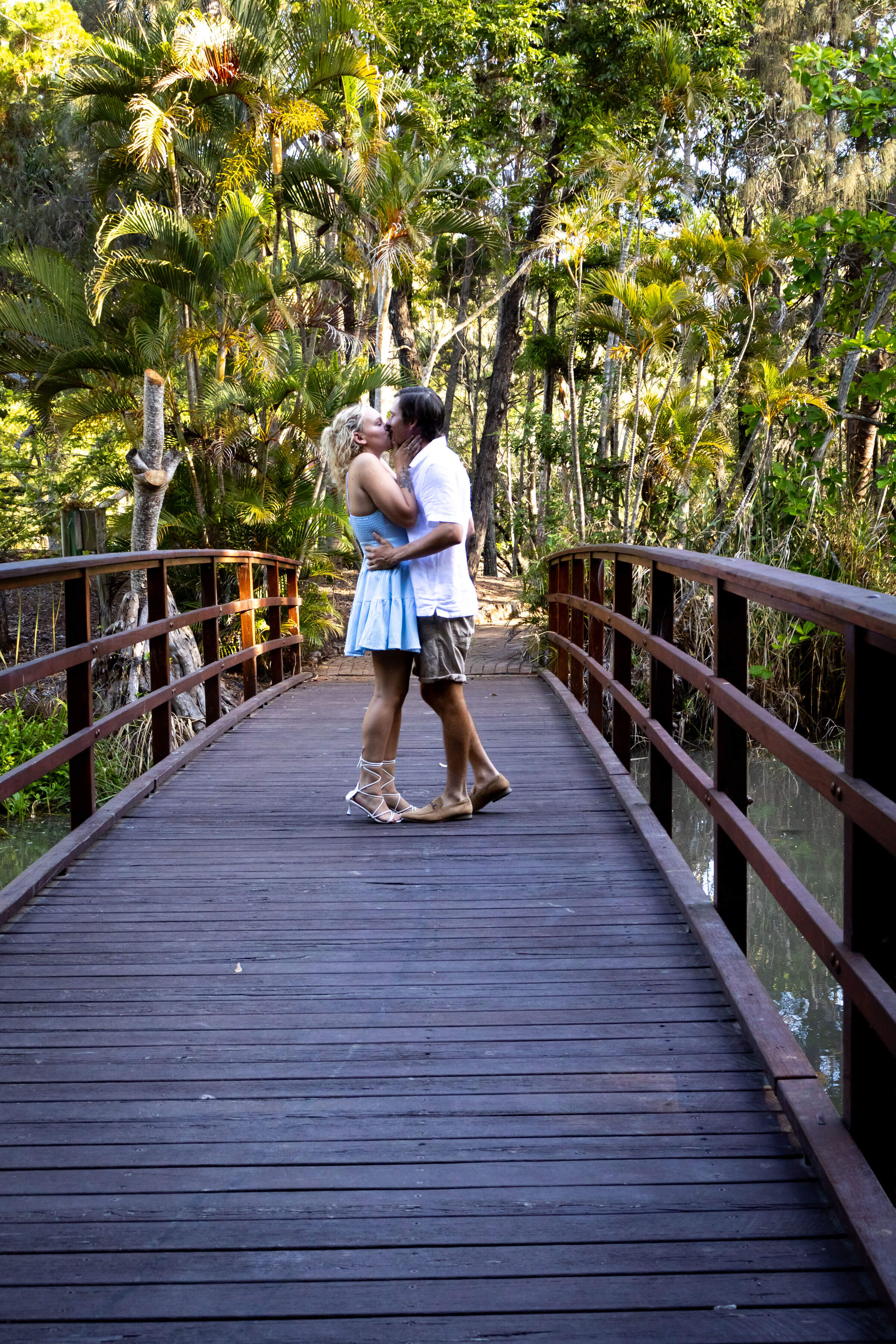 a loving couple kissing on a bridge