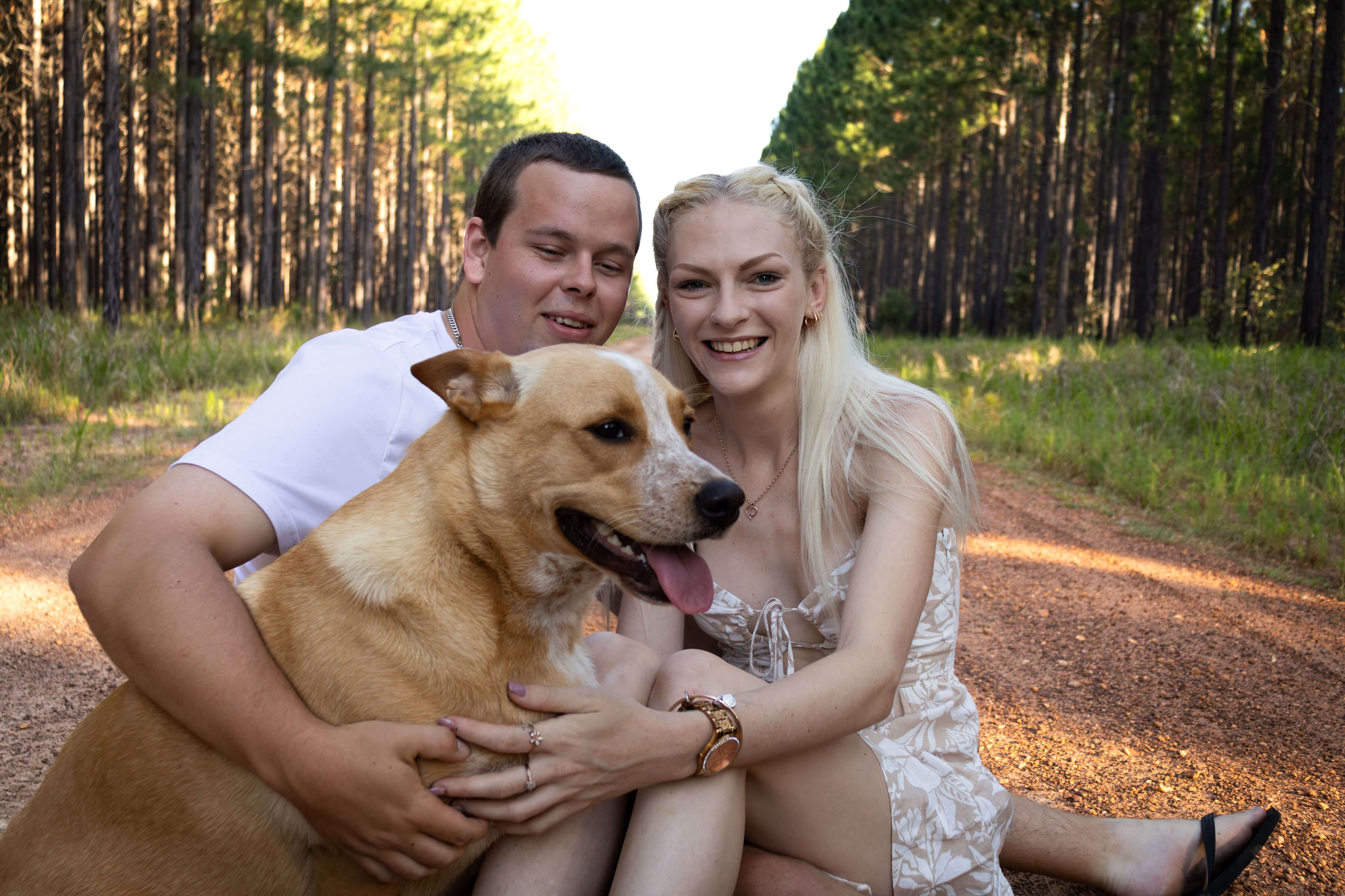 a couple cuddling their dog