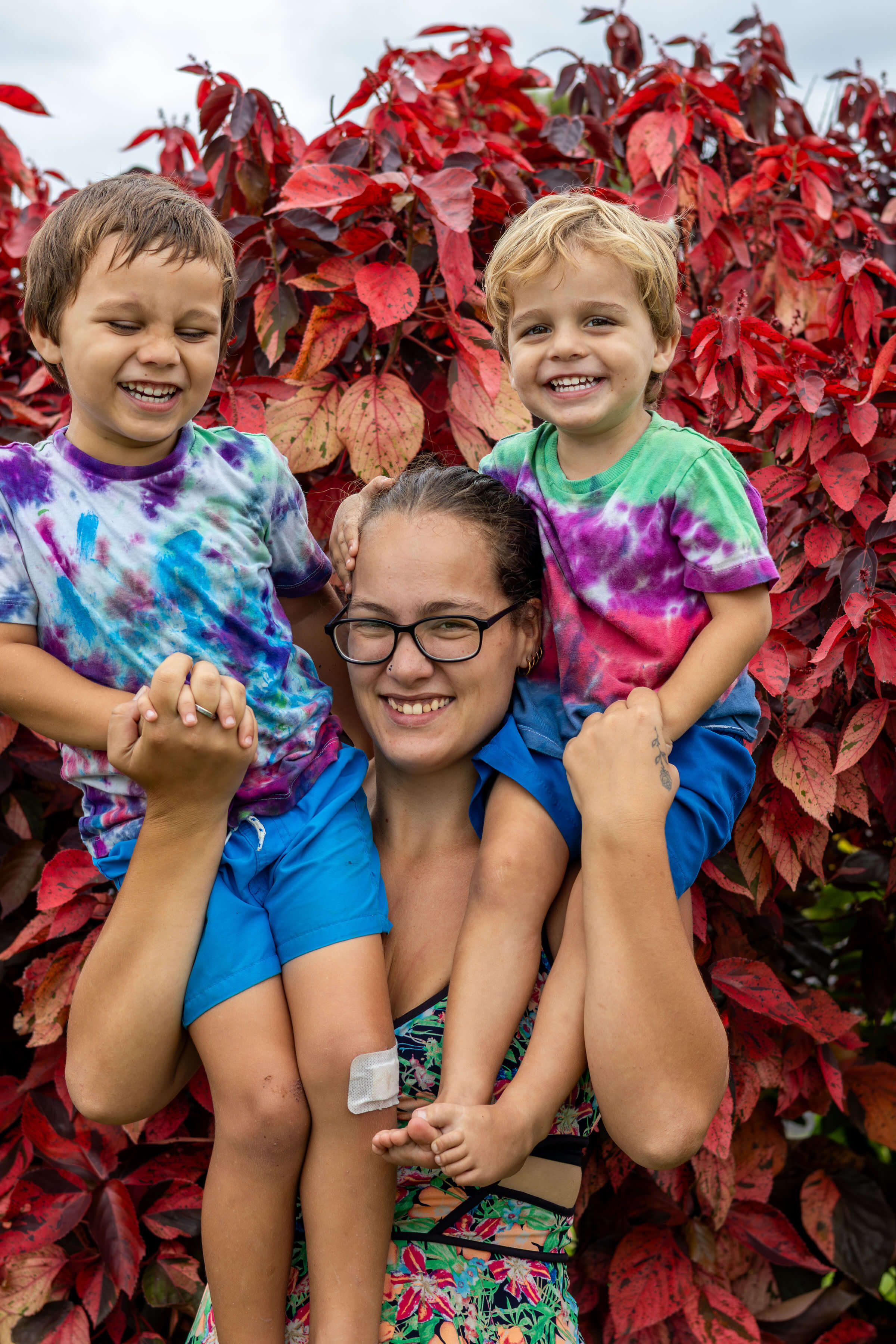a mum holding two children on her shoulder