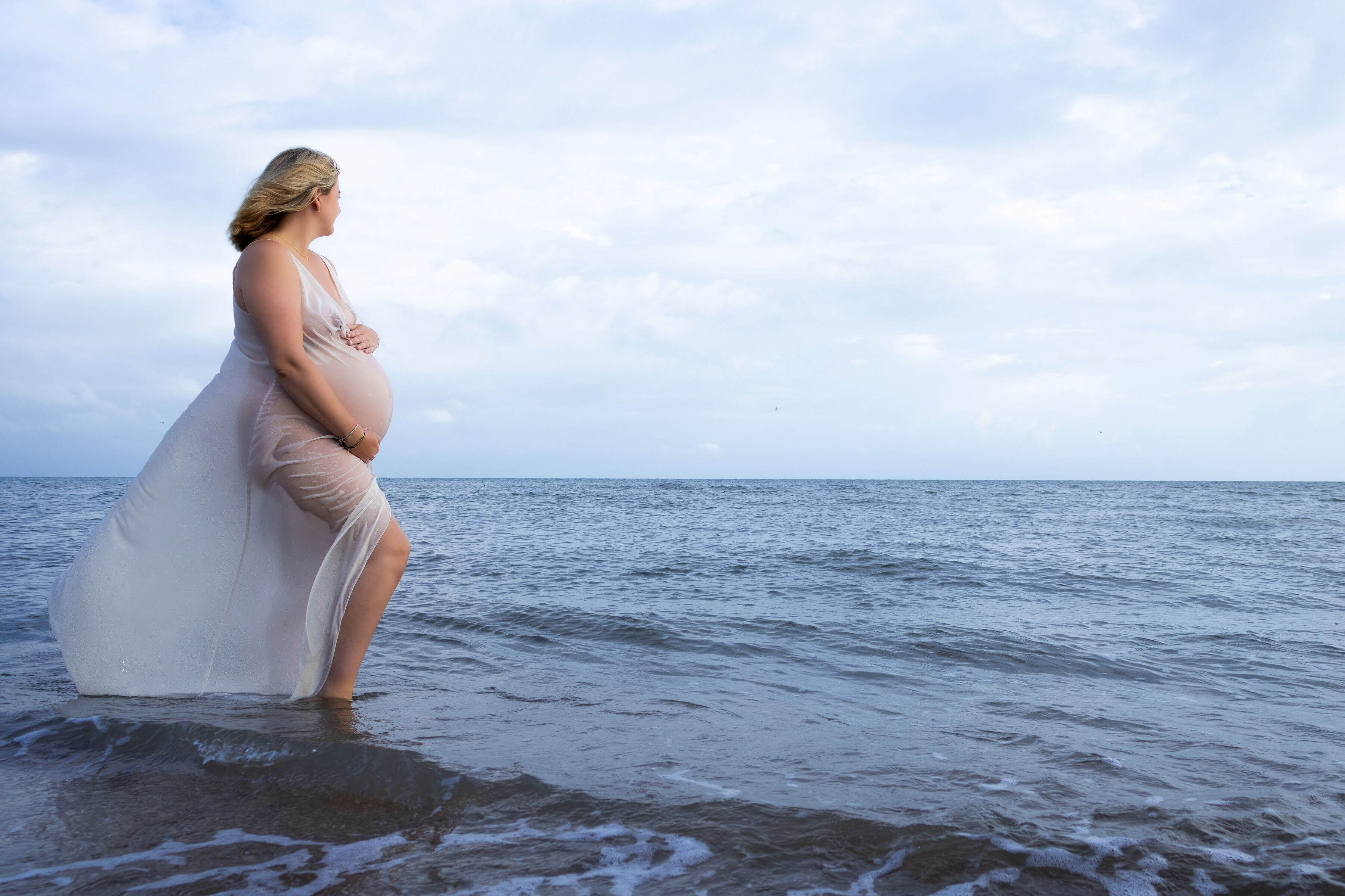 a women in a dress looking out over the ocean